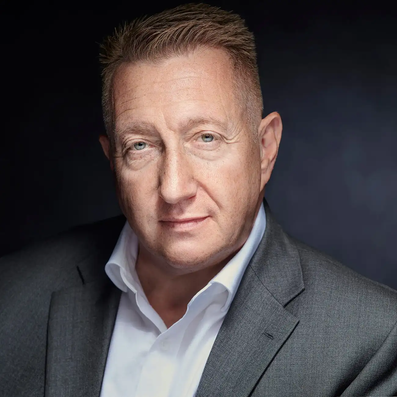 Professional corporate portrait of a man in a grey suit
