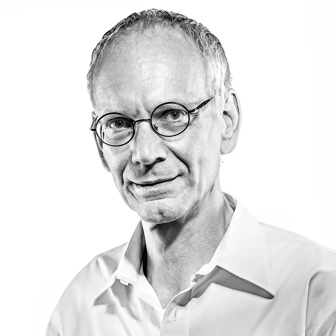 Black and white corporate portrait of a man with round glasses